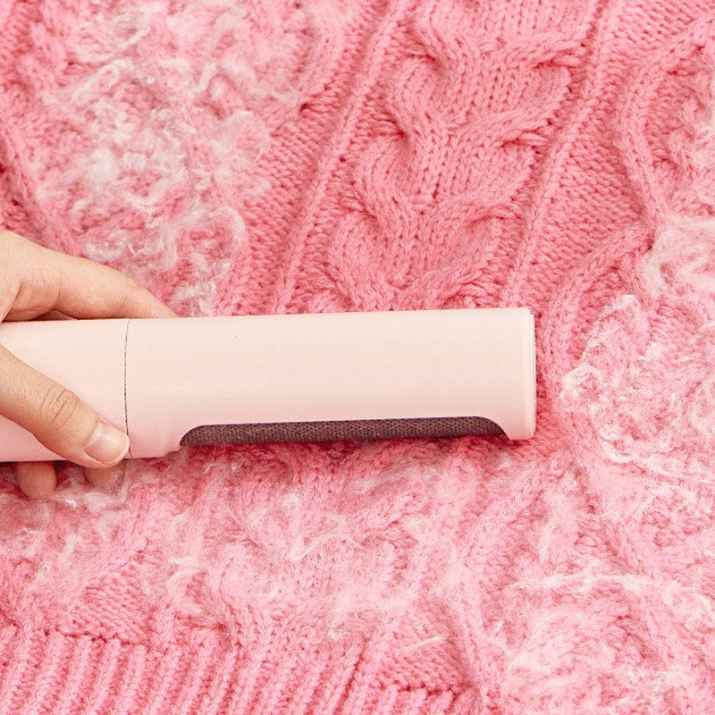 Pet hair roller in use on pink knit sweater